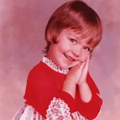 Alexis sorrindo quando criança