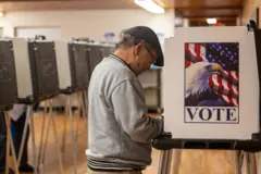 Homem deposita votoesportenet net betum localesportenet net betvotação antecipada na Carolina do Norte na imagem, aparece a urna com o símboloesportenet net betvotação, onde está escrito "vote" e a fotoesportenet net betuma águia com a bandeira dos EUA