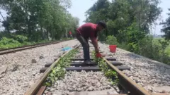 বাঁকা হয়ে যাওয়া রেল লাইনে পানি দিচ্ছেন শ্রমিকরা