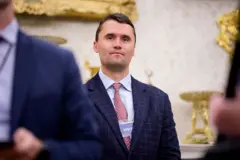 Imagem de Charlie Kirk em trajes sociais, em um evento