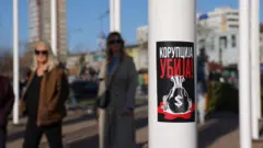 Na banderi je poster na kojem piše - korupcija ubija a ispod je nacrtan džak sa simbolom američkog dolara
