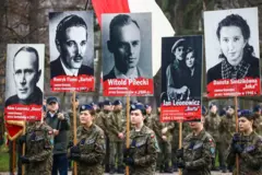 Mujeres uniformadas sostienen pancartas con las fotos de Witold Pilecki y otros mártires anticomunistas en la llamada marcha de los "soldados malditos"