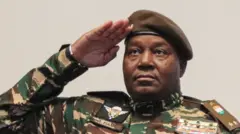 General Abdourahamane Tchiani salute as e wear military fatigues