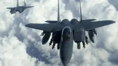 Два истребителя F-15 в небе над облаками