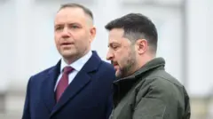 Prezydent Polski Karol Nawrocki (z lewej) w granatowym płaszczu, białej koszuli i czerwonym krawacie stoi obok prezydenta Ukrainy Wołodymyra Zełenskiego (z prawej), który ma na sobie zieloną kurtkę w stylu wojskowym 