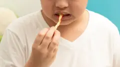 フライドポテトを食べる子供の画像