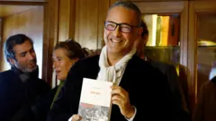 الكاتب الفرنسي الجزائري، كمال داود، يلتقط صورة بعد حصوله على جائزة غونكور الأدبية الفرنسية عن روايته "الحوريات"، في مطعم دروانت في باريس، فرنسا، 4 نوفمبر/تشرين ثاني 2024. 