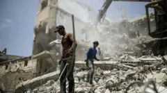 Dos hombre estan entre los escombros de Gaza
