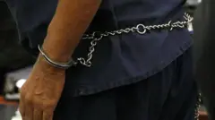 Ọwọ ti wọn so ṣẹkẹṣẹkẹ mọ sẹyin