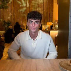 Tom Thebe sentado à mesa de um restaurante