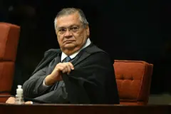 Ministro Flávio Dino sentado e usando toga