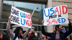 Aworan awọn olufẹhonuhan ti ko fẹ ki wọn fagile ajọ USAID. Iwaju Olu ileeṣẹ naa ni wọn tẹ pẹpẹ ifẹhonuhan naa si l'America.