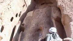 ایک طالبان جنگجو مجسمے کی طرف دیکھ رہا ہے