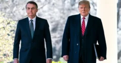 Foto mostrando Jair Bolsonaro e Donald Trump durante visita do brasileiro aos Estados Unidos, em 2019. Os dois usam ternos e sobretudos escuros