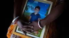 చనిపోయిన బాబు ఫోటో పట్టుకున్న తల్లి