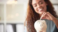 Pesin wey dey put money for piggy bank