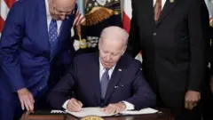 biden yasayı imzalarken