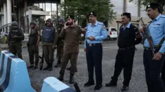Oficiais de segurança paquistaneses uniformizados e armados em uma barreira em uma rua de Islamabad, no dia 9 de abril de 2026