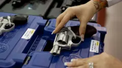 Mulher segura arma em uma loja