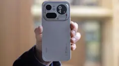 Uma mão segura um smartphone.