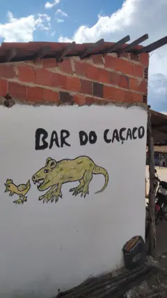 Pintura feita à mão na parede de bar em Exu, Pernambuco, mostra um rato perseguindo uma galinha