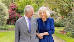 King Charles and Queen Camilla smiling and posing hand in hand