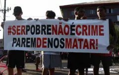 Jovens seguram faixa durante protesto contra operação na Baixada Santista