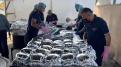 Hombres en la cocina comunitaria preparando paquetes de comida