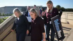 Kadın gazeteciler ellerine eşyalarıyla sıra halinde Pentagon'dan çıkıyor