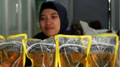 Petugas menata stok minyak goreng saat operasi pasar pangan murah di Kantor Pos Indonesia, Malang, Jawa Timur (4/3). Kementerian Pertanian menemukan Minyakita 1 Liter di pasaran, hanya berisi 750-800 mililiter.