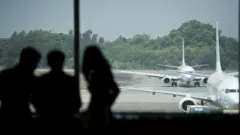 ရန်ကုန်လေဆိပ်မှာ ဆိုက်ကပ်ထားတဲ့လေယာဥ်တွေနဲ့ လေယာဥ်ပေါ် တက်ဖို့ စောင့်ဆိုင်းနေသူတွေ 