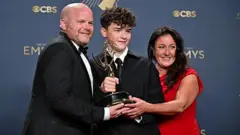 అవార్డు గెలుచుకున్న కుమారుడు కూపర్‌తో తల్లిదండ్రులు నోరీన్, ఆండీ