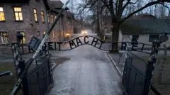 Ujęcie z drona przedstawiające bramę „Praca czyni wolnym” na terenie byłego niemieckiego nazistowskiego obozu koncentracyjnego i zagłady Auschwitz
