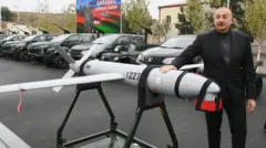 İlham Əliyev sərhəd xidmətinin hərbi hissələrinin birində xaricdən alınan dronun üzərinə əlini qoyaraq şəkil çəkdirib