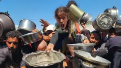 Hombres, mujeres y niños buscan comida en Gaza. 