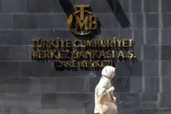 Merkez bankası binasının önünde yürüyen bir kadın 