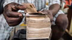 Homem manipula grande maço de notas de naira