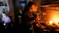 ሻማ እያበራች ምግብ የምትሰራ ሴት 