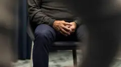 Un homme assis sur une chaise