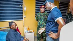 Arabinrin FR Alamu wọ aṣọ olomi buluu, ọgagun sọja kan wọn aṣọ ologun, Gomina Seyi Makinde naa wọ aṣọ olomi buluu pẹlu fila