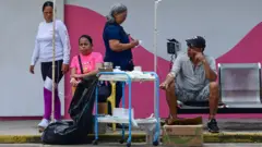 Pessoas sendo atendidas na rua em Morón, no Estado de Carabobo, Venezuela