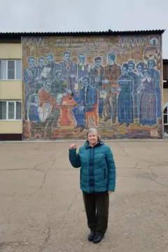 Filonova em frente a um mosaico que mostra os rebeldes dezembristas, lendo a mensagem de Alexander Pushkin: "Nas profundezas das minas siberianas".