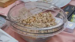 Recipiente de vidro contendo flocos de maná sobre uma mesa