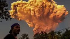 Seorang warga Desa Talibura di Sikka, Nusa Tenggara Timur, menyaksikan erupsi Gunung Lewotobi Laki-Laki pada 17 Juni 2025.