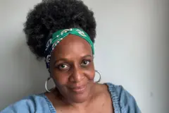 Venessa Swaby sorrindo contra um fundo cinza