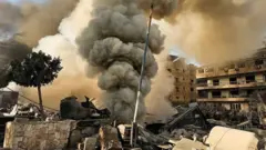 Coluna de fumaça saindo de prédios bombardeados