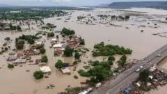 This areal view shows houses submerged by water in a flooded area in Adaha, on October 22, 2024.
