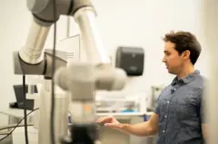 Um homem em um laboratório mexendo em um aparelho