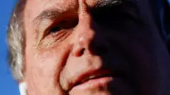 Close no rosto de Jair Bolsonaro, um homem idoso branco