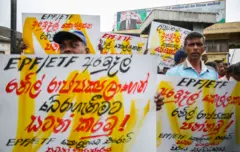 Members of the Sri Lanka Ports Authority are protest holding placards with the slogan ''Save EPF and ETF funds from Ranil Rajapaksa government'' in front of the entrance of the Ports Authority in Colombo on 10 July 2023